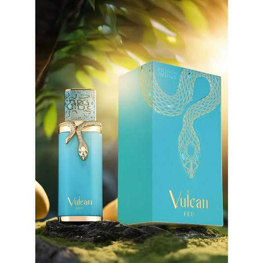 A fragrance bottle with a blue label and a decorative element that resembles a snake, alongside its packaging box with a similar design, displayed against a natural background with greenery.